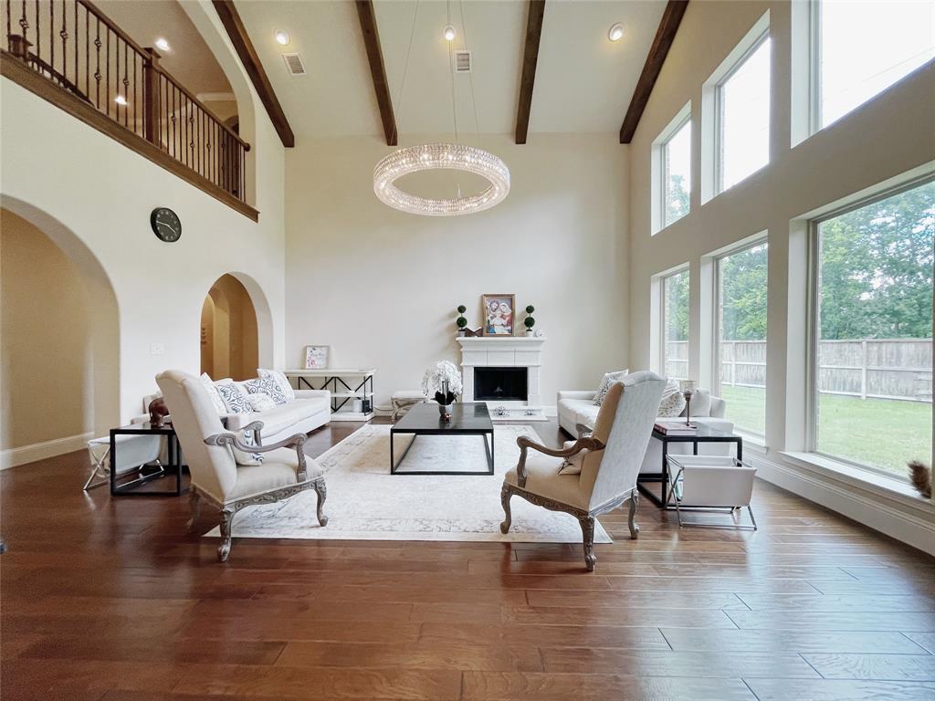 a living room with couches and a dining table with wooden floor