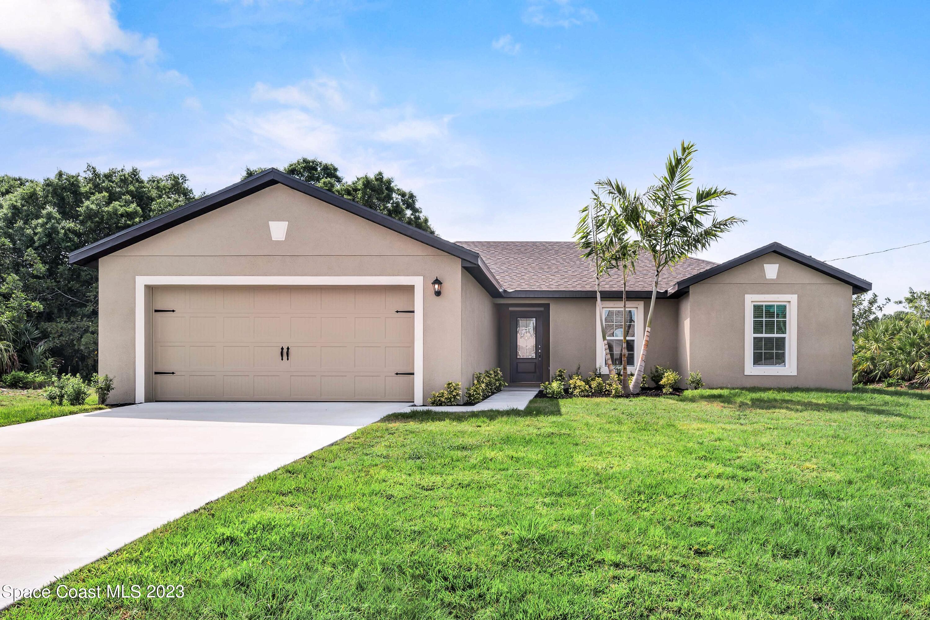 a front view of a house with a yard and garage