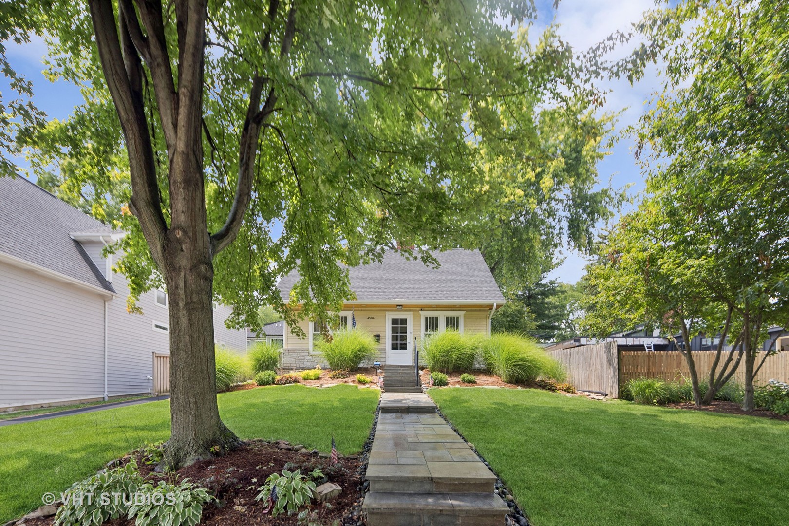 a front view of a house with yard and green space