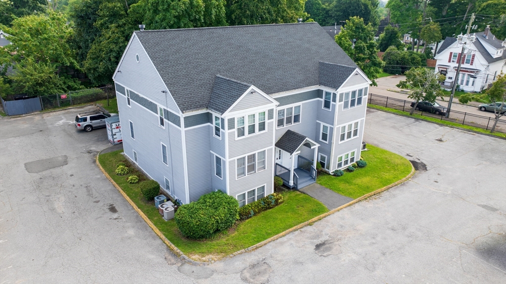 a aerial view of a house with a yard and potted plants