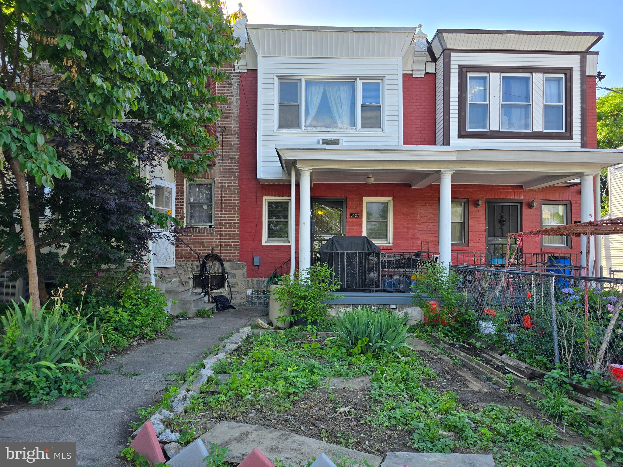 a view of a brick house with many windows and plants