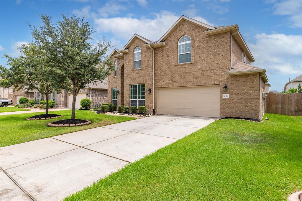 a front view of a house with a yard and garage