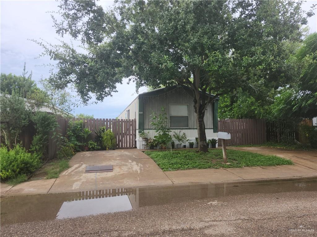 a front view of a house with garden and trees