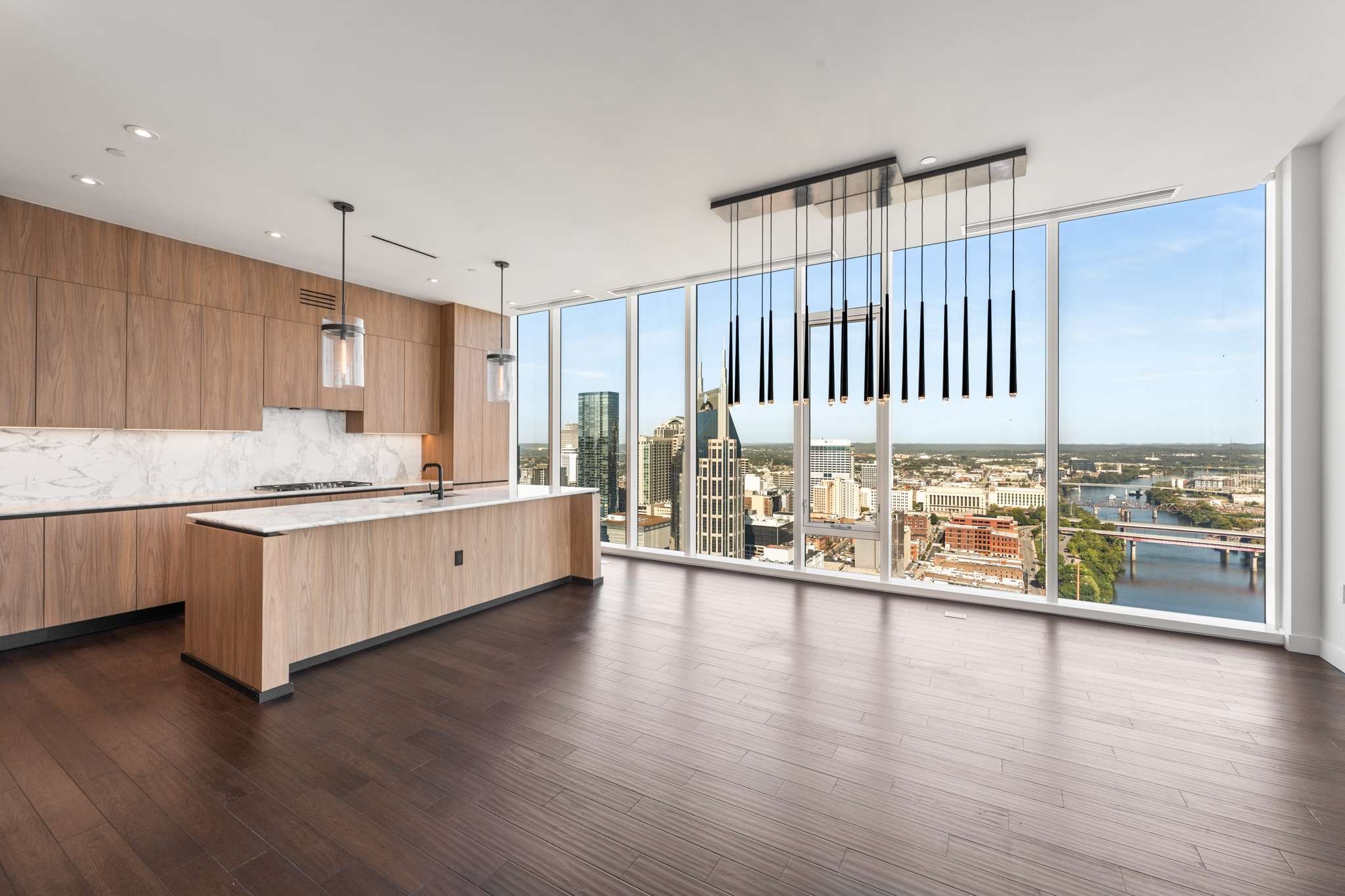 a large white kitchen with a large window and stainless steel appliances