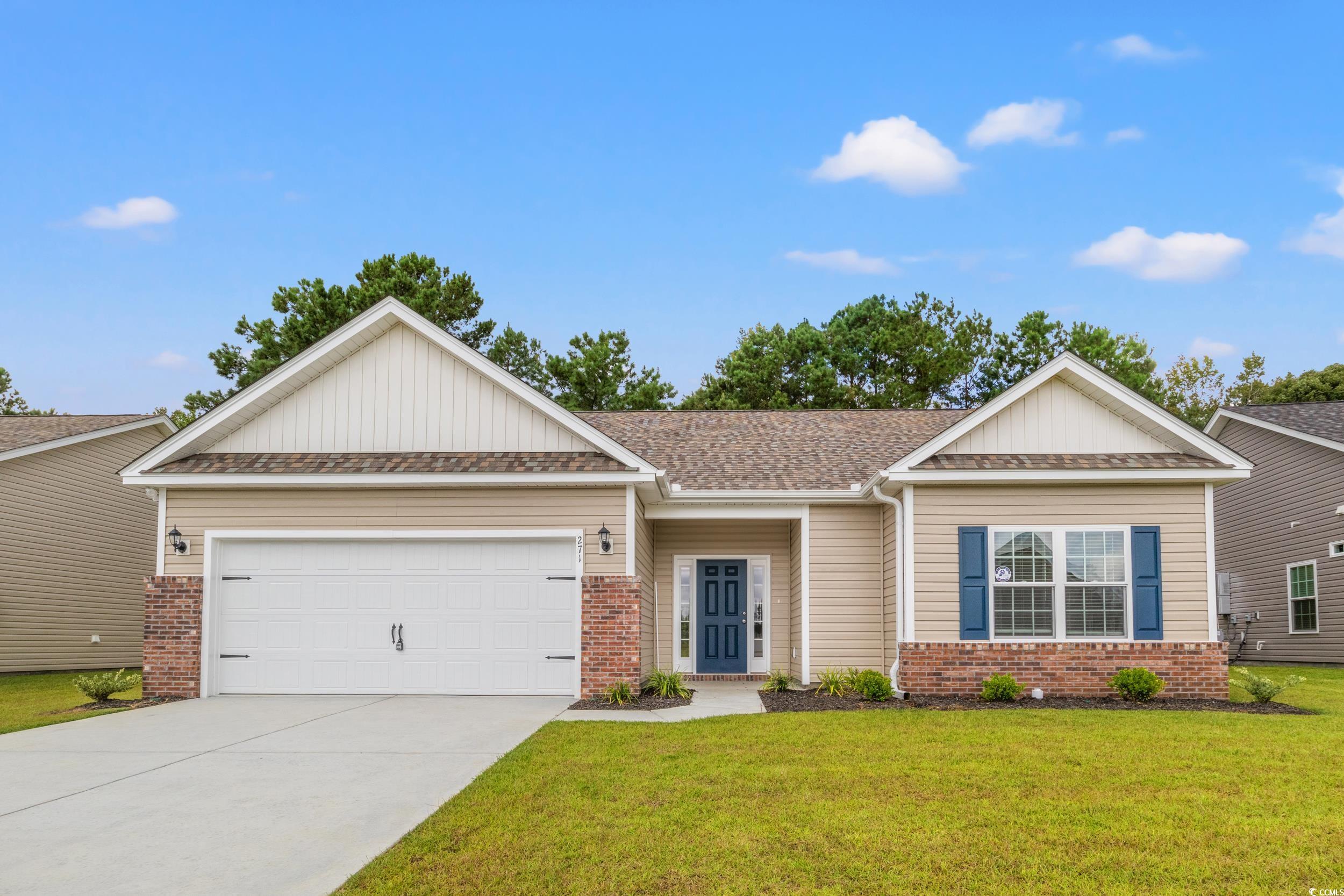 View of front of home with a front yard and a gara