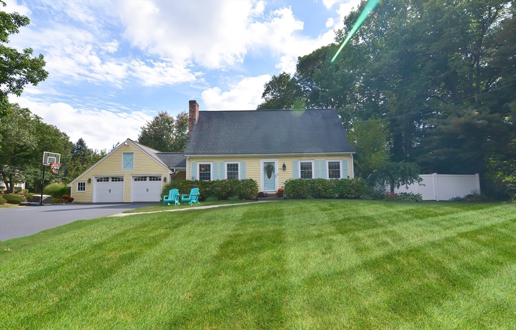 a front view of a house with a yard and trees