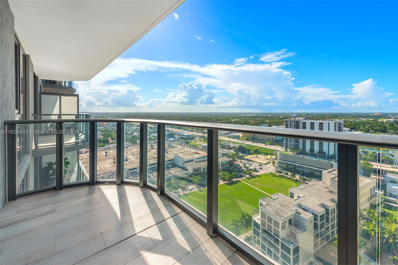 a view of balcony with wooden floor & fence