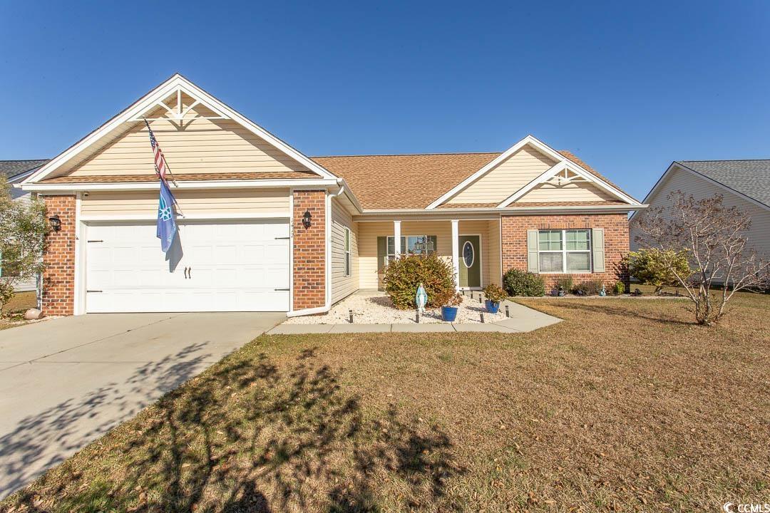 Single story home featuring a front yard and a gar