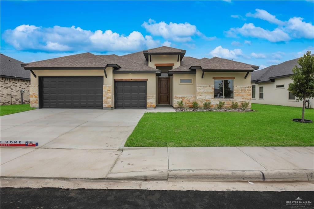 Prairie-style home featuring a front yard and a garage