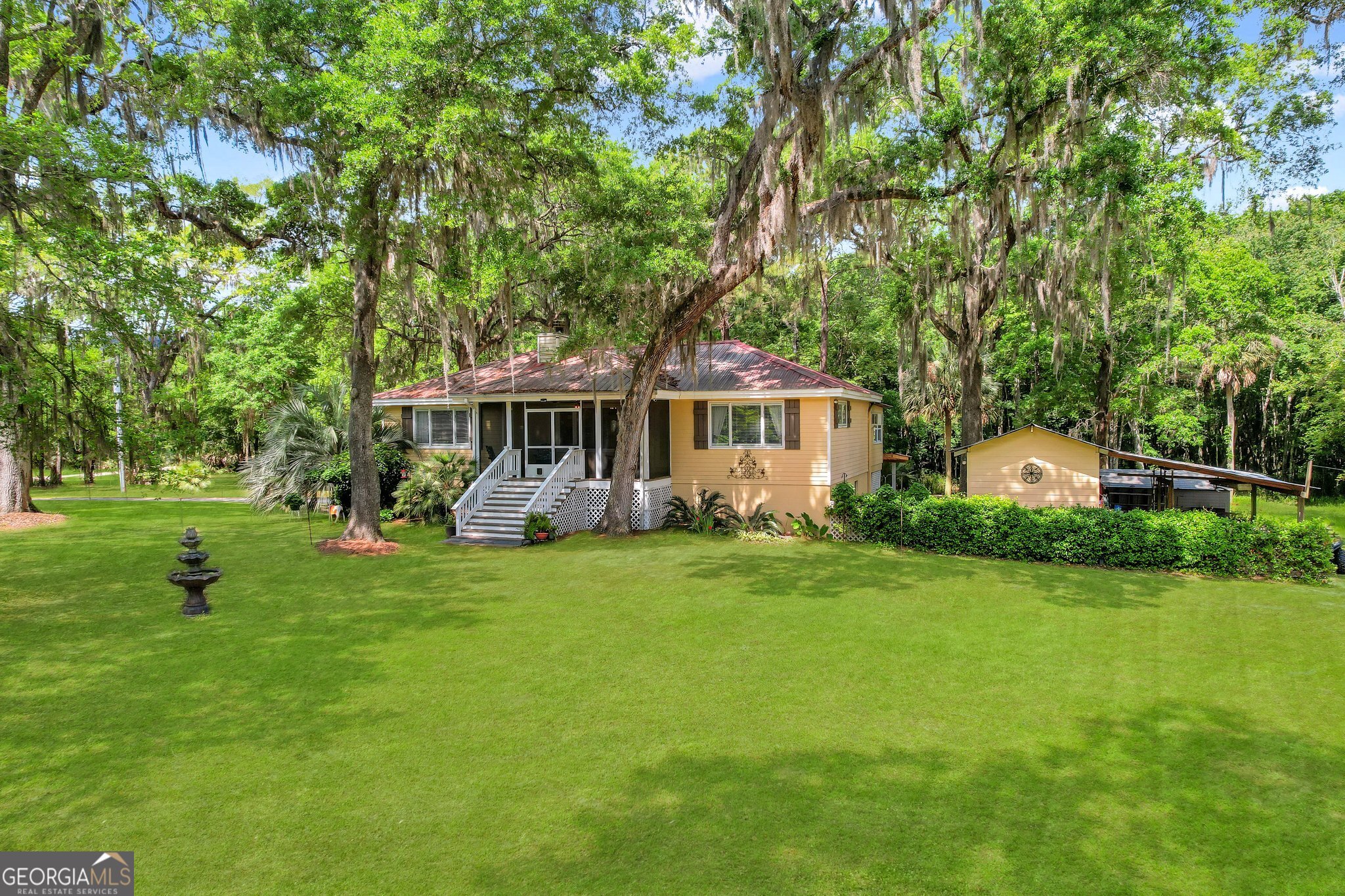 a front view of a house with a yard and trees