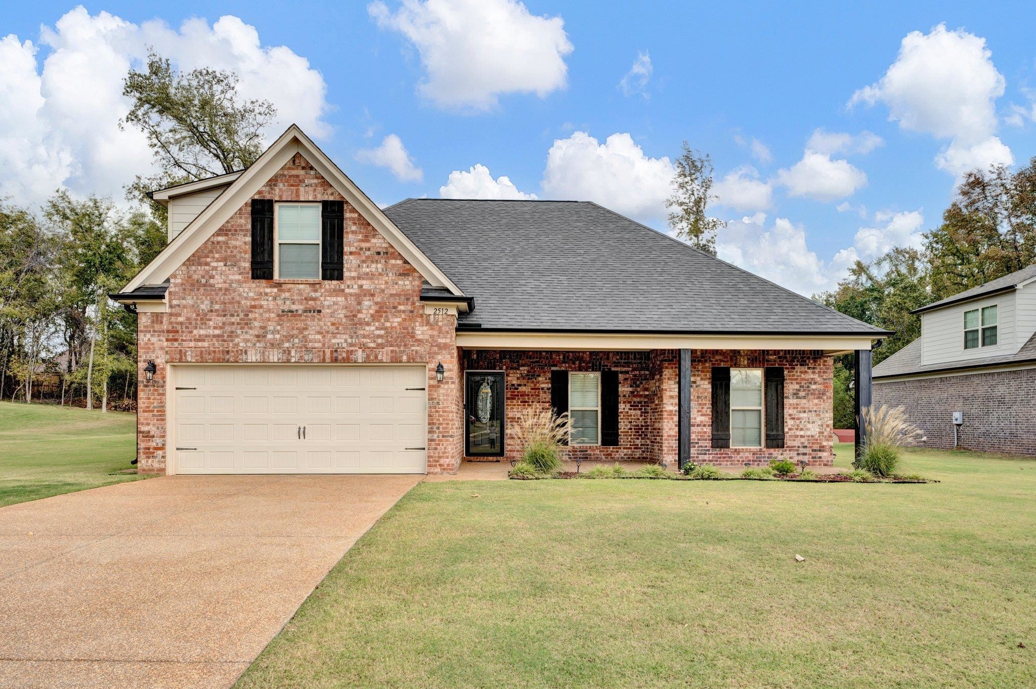 View of front facade featuring a front lawn and a garage