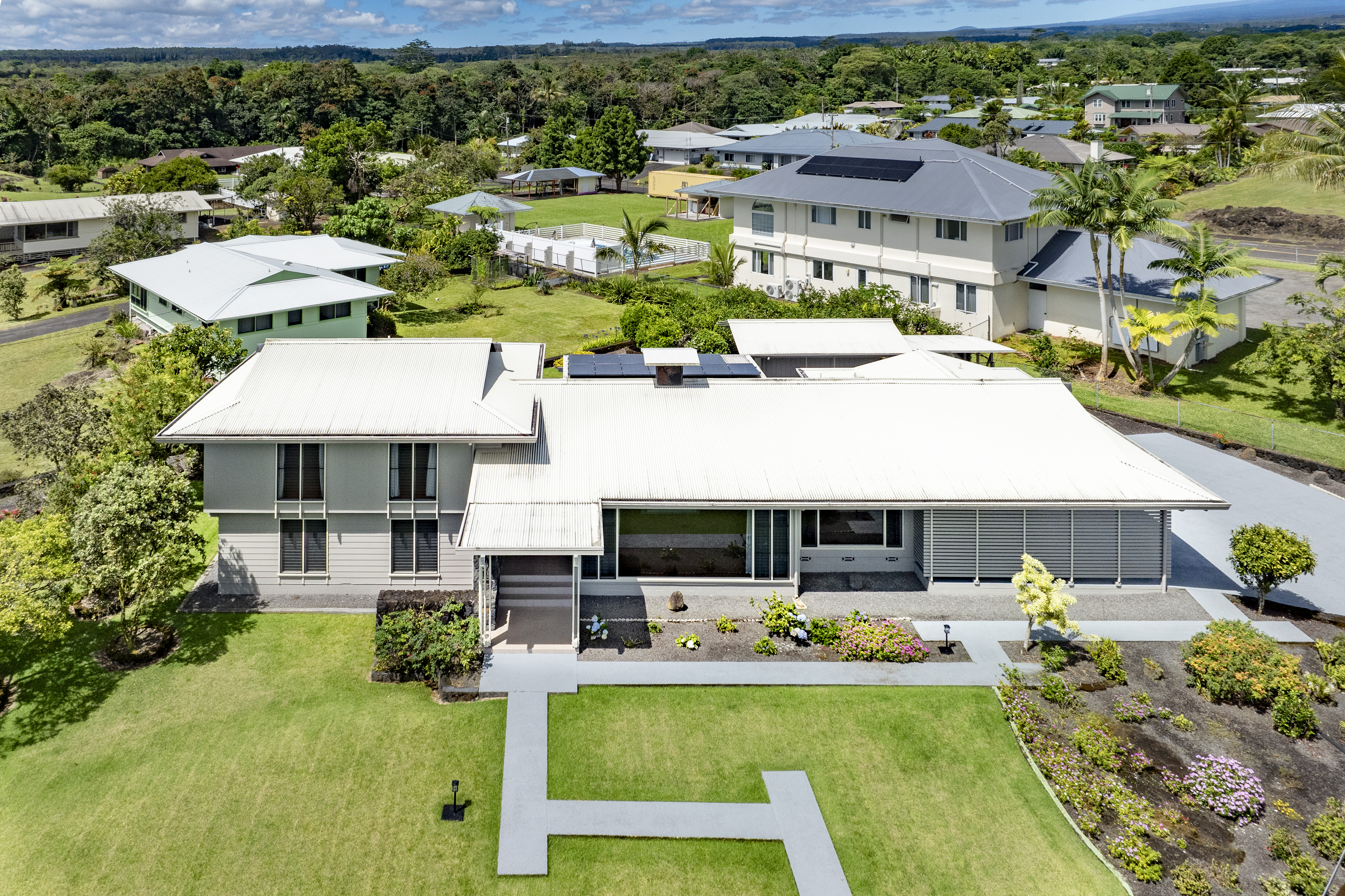 a front view of a house with swimming pool garden and patio