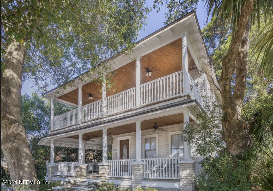 a front view of a house with a tree