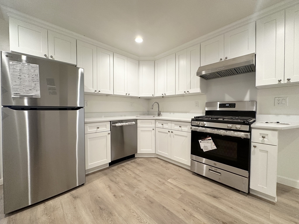 a kitchen with a stove a sink and a refrigerator