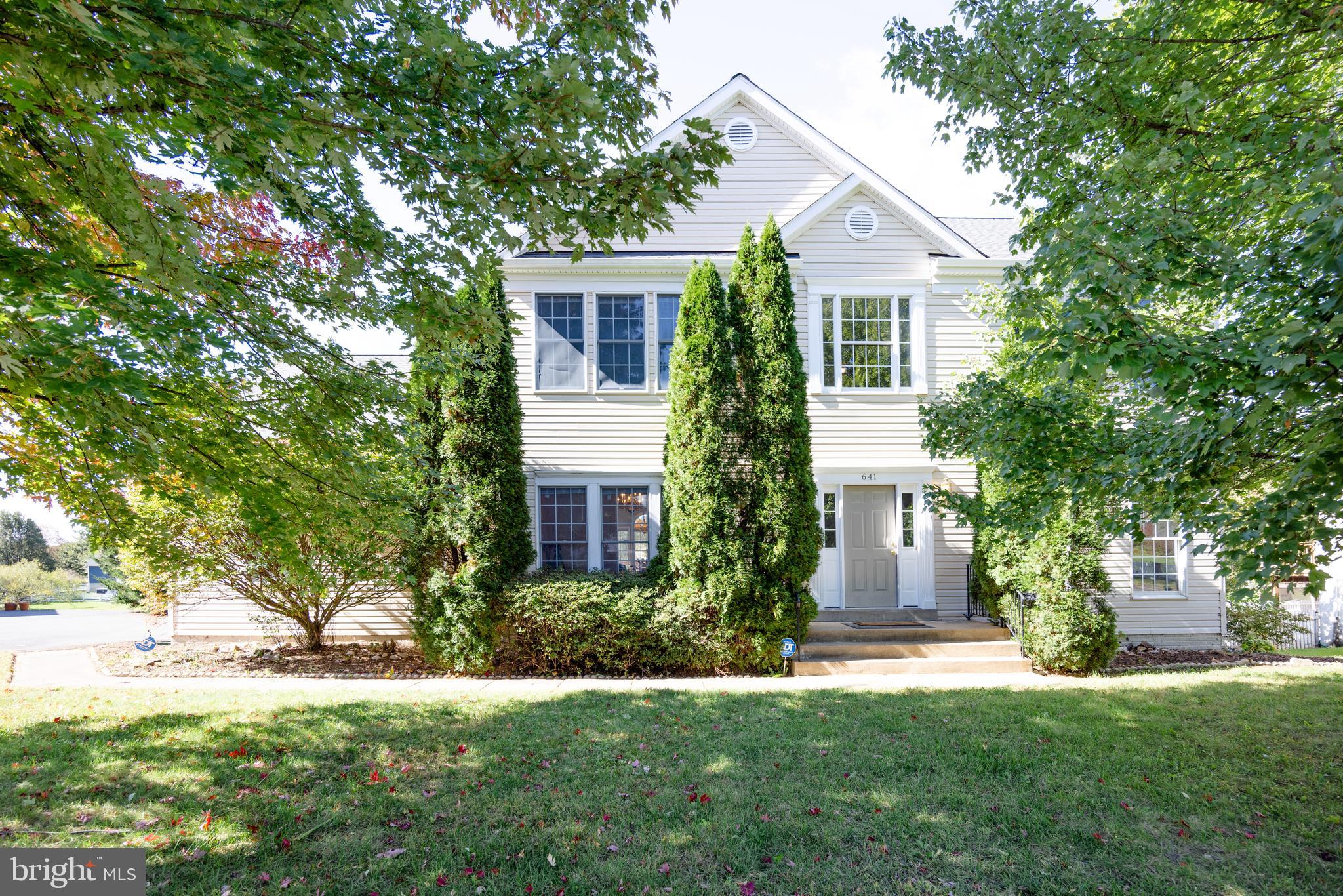 a front view of a house with a yard and trees