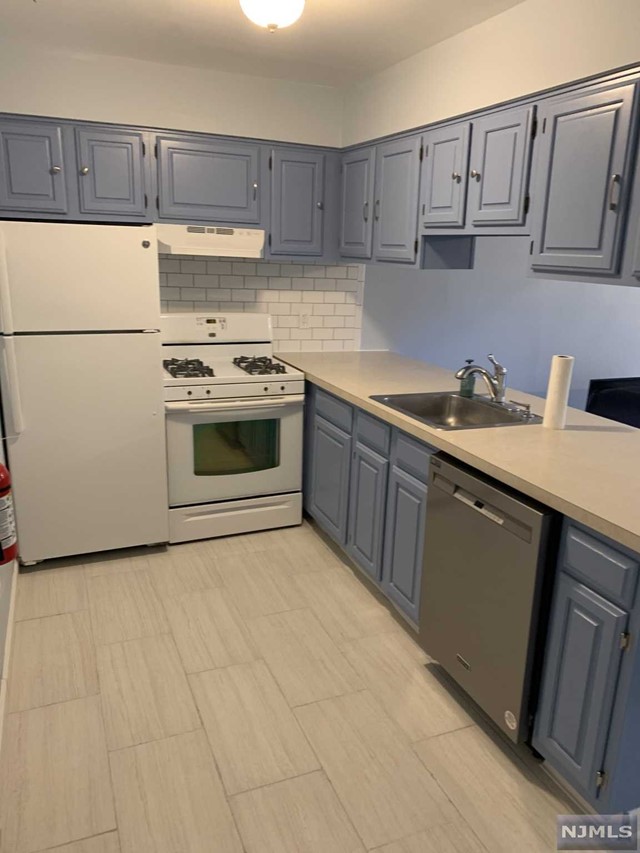 a kitchen with a sink a stove and cabinets