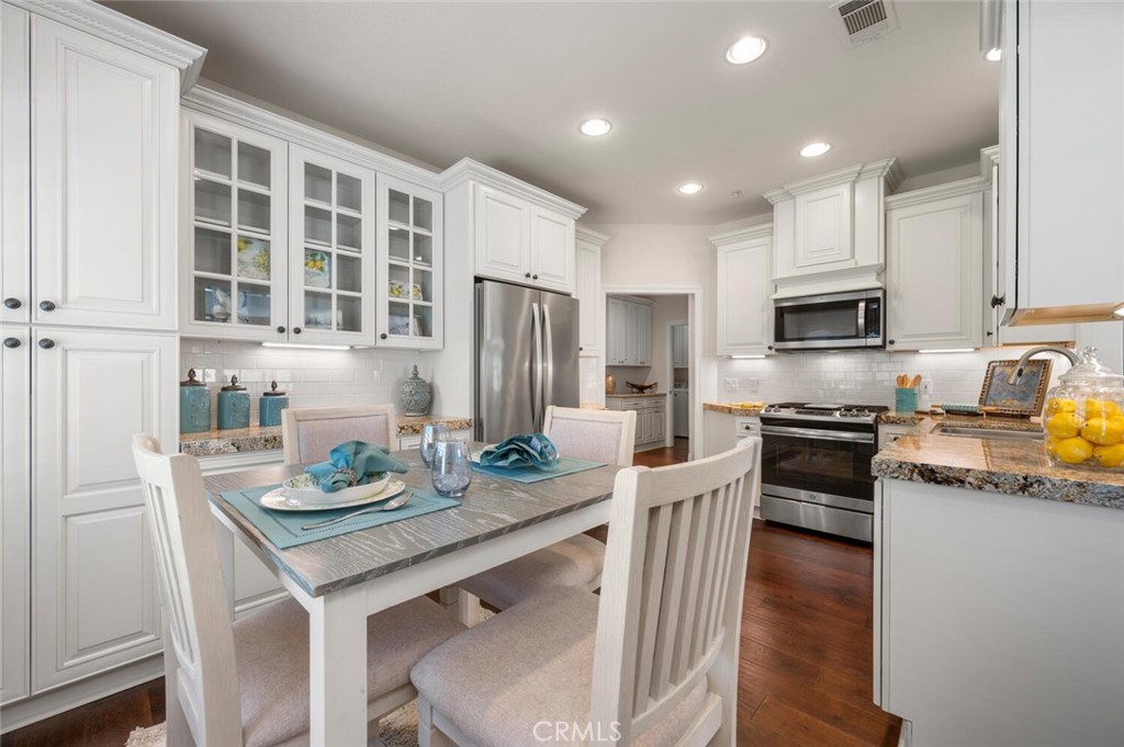 a kitchen with granite countertop stainless steel appliances and wooden floor