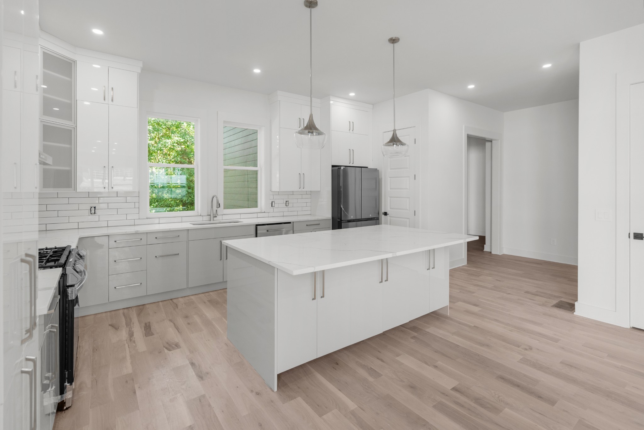 a kitchen with a refrigerator a sink and wooden floor