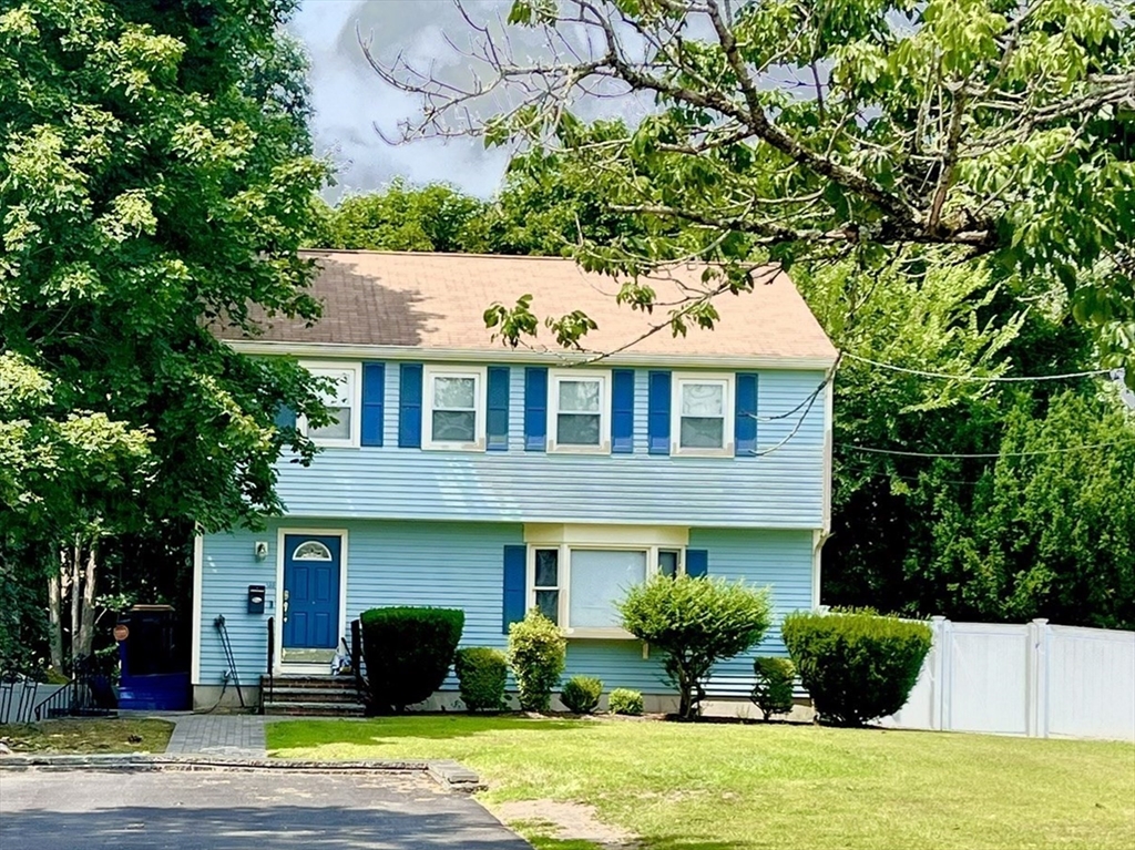 a front view of a house with a yard and potted plants