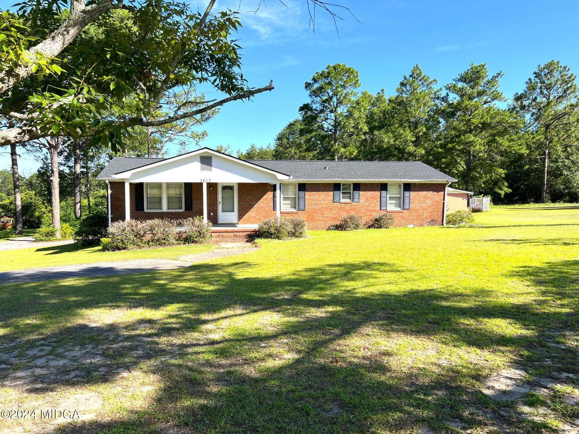 a front view of a house with swimming pool and yard