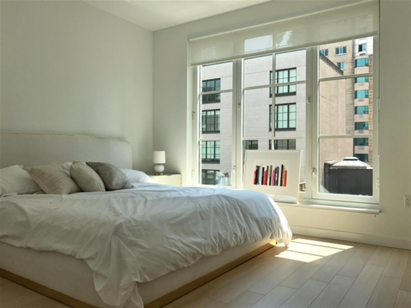 a bedroom with a bed and a large window