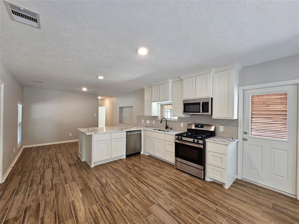 a kitchen with a sink a microwave and cabinets