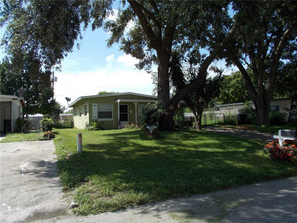 a front view of a house with a garden and trees