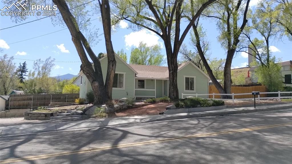 a view of a house with backyard and trees