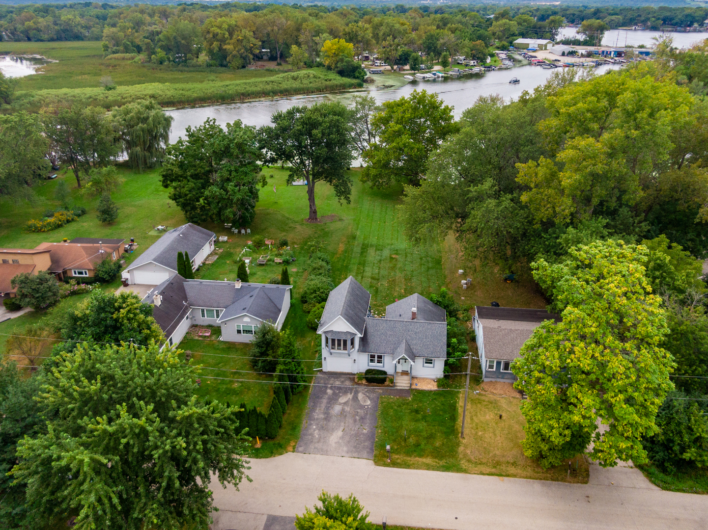 an aerial view of a house with outdoor space and lake view in back