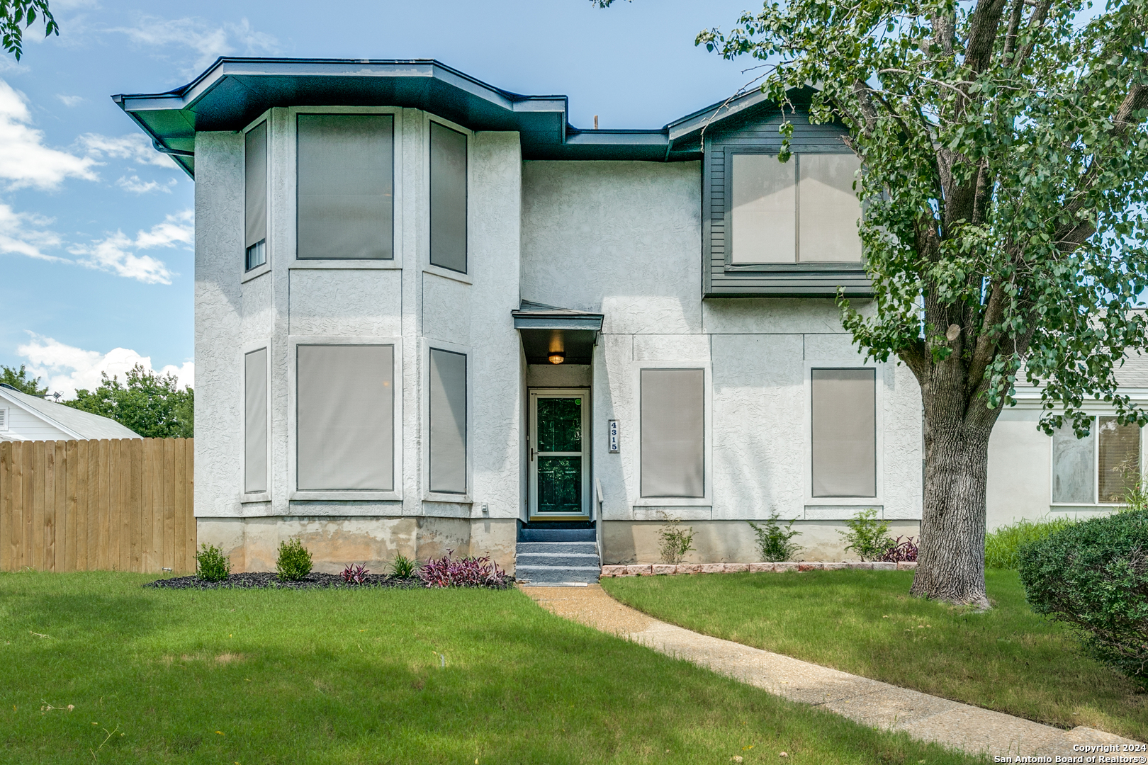 a front view of a house with a garden