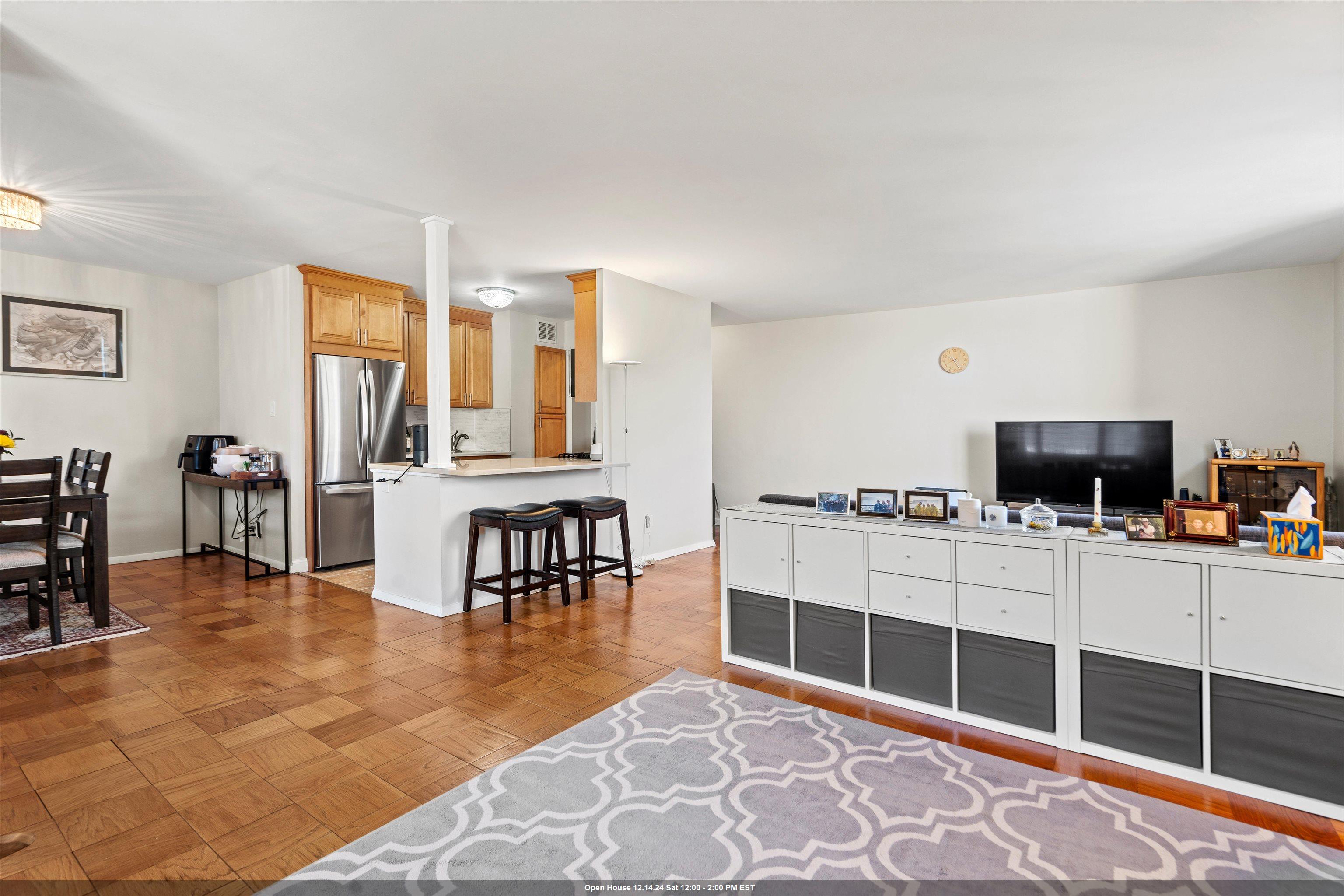 a living room with furniture a flat screen tv and kitchen view