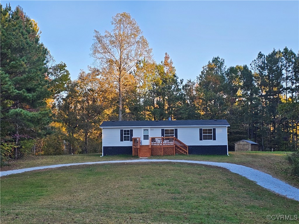 a front view of house with yard and trees in the background