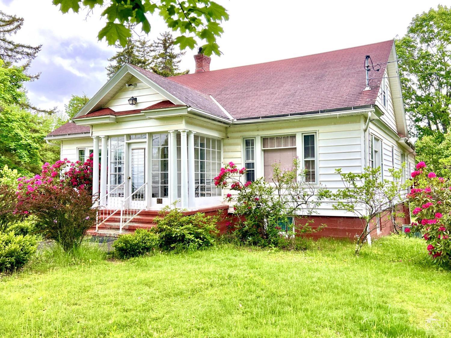 a front view of a house with a yard table and chairs