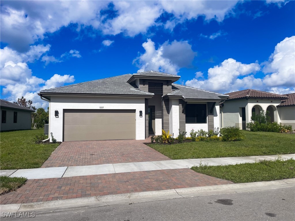 a front view of a house with a yard and garage