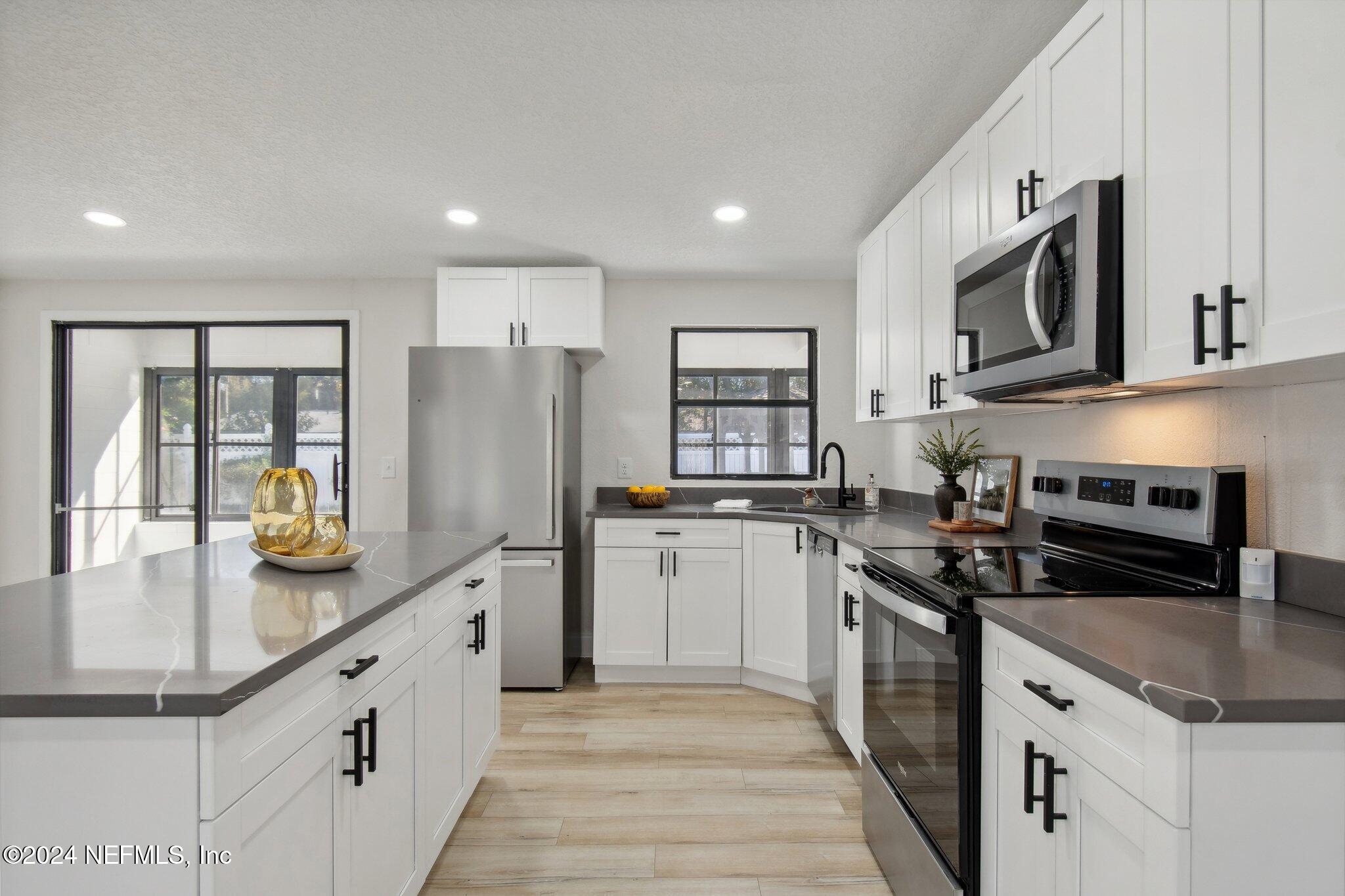 a kitchen with stainless steel appliances granite countertop a sink and stove top oven