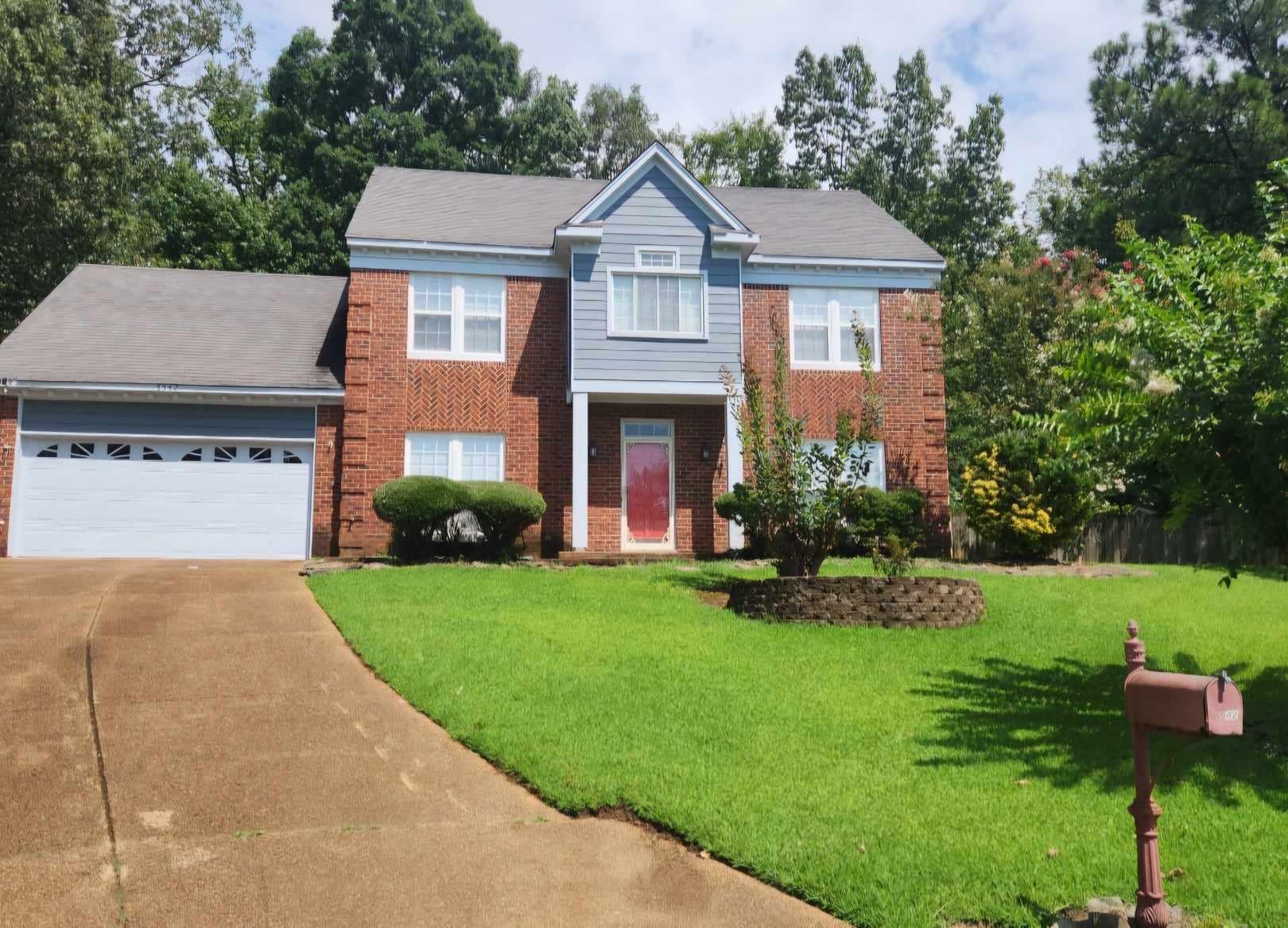 a front view of a house with a yard and trees