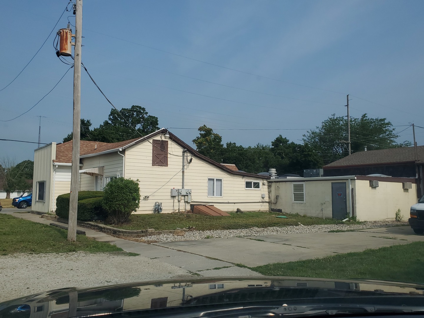 a view of a white house next to a yard and road