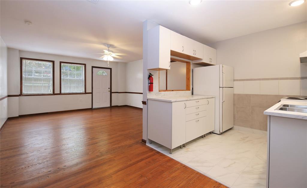 a kitchen with a wooden floor and white cabinets