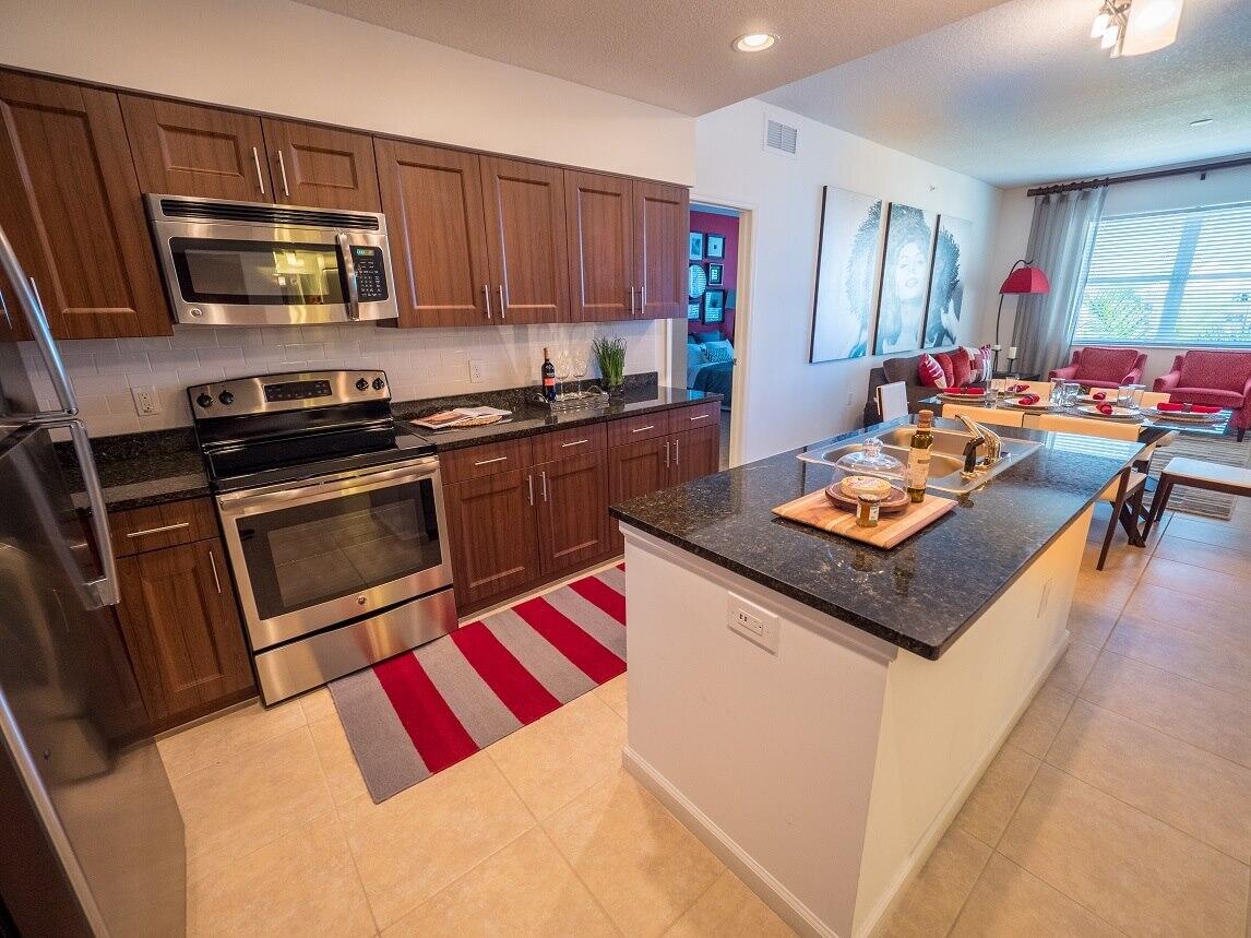 a kitchen with stainless steel appliances a stove a microwave a sink a stove and cabinets