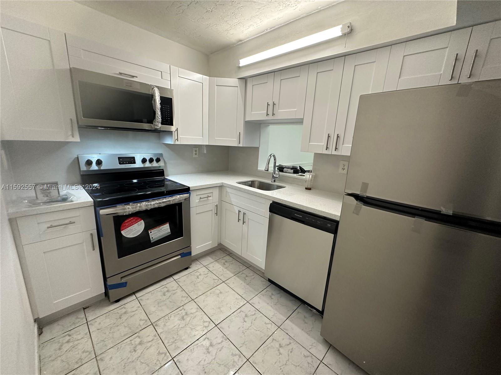 a kitchen with a sink appliances and cabinets