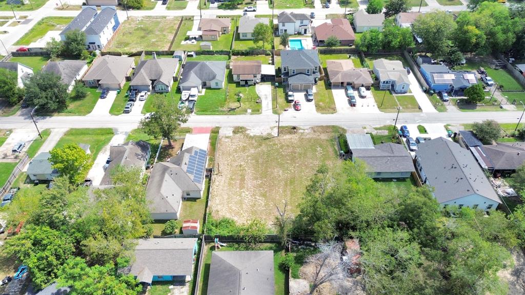 an aerial view of residential houses with outdoor space and parking