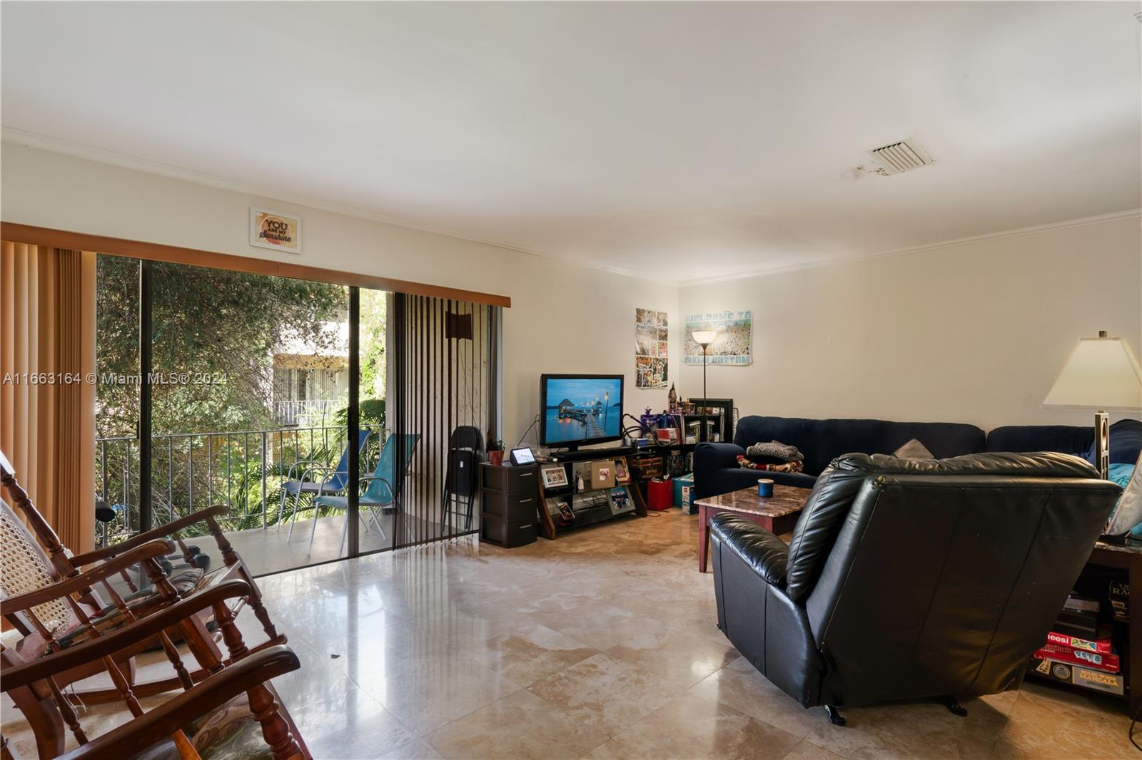 a living room with furniture a flat screen tv and floor to ceiling window