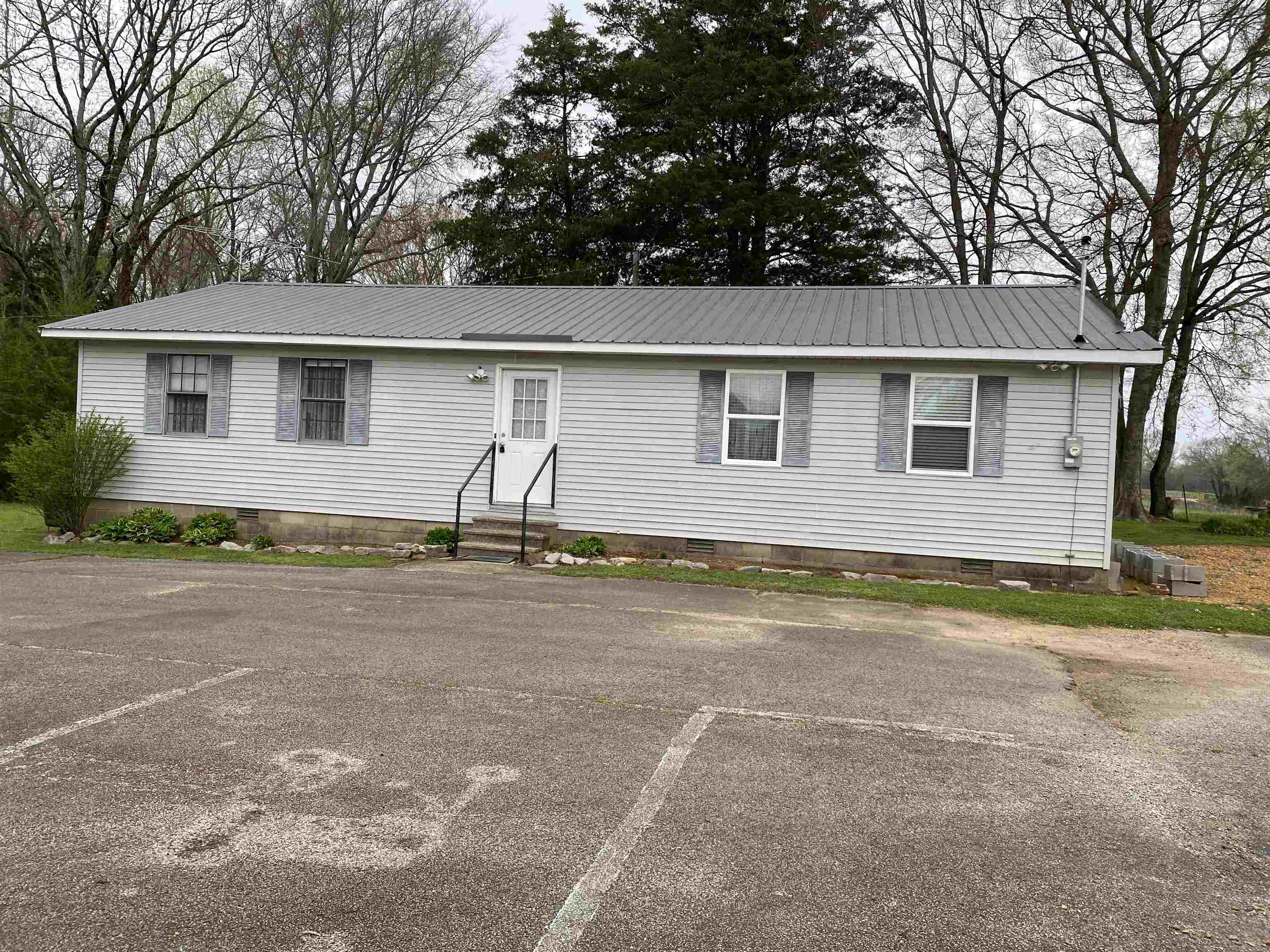 a front view of house with yard and trees around