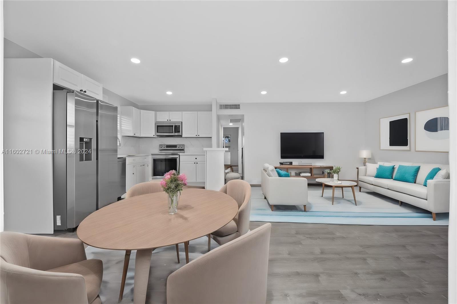 a living room with furniture a flat screen tv and kitchen view