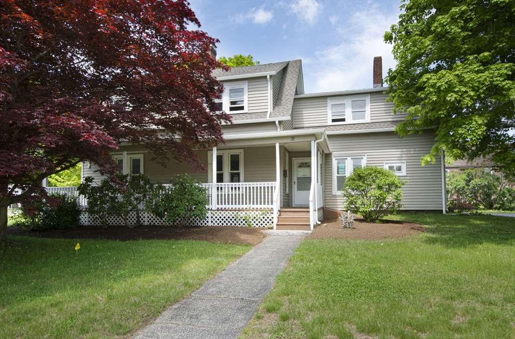 a front view of a house with a garden and yard