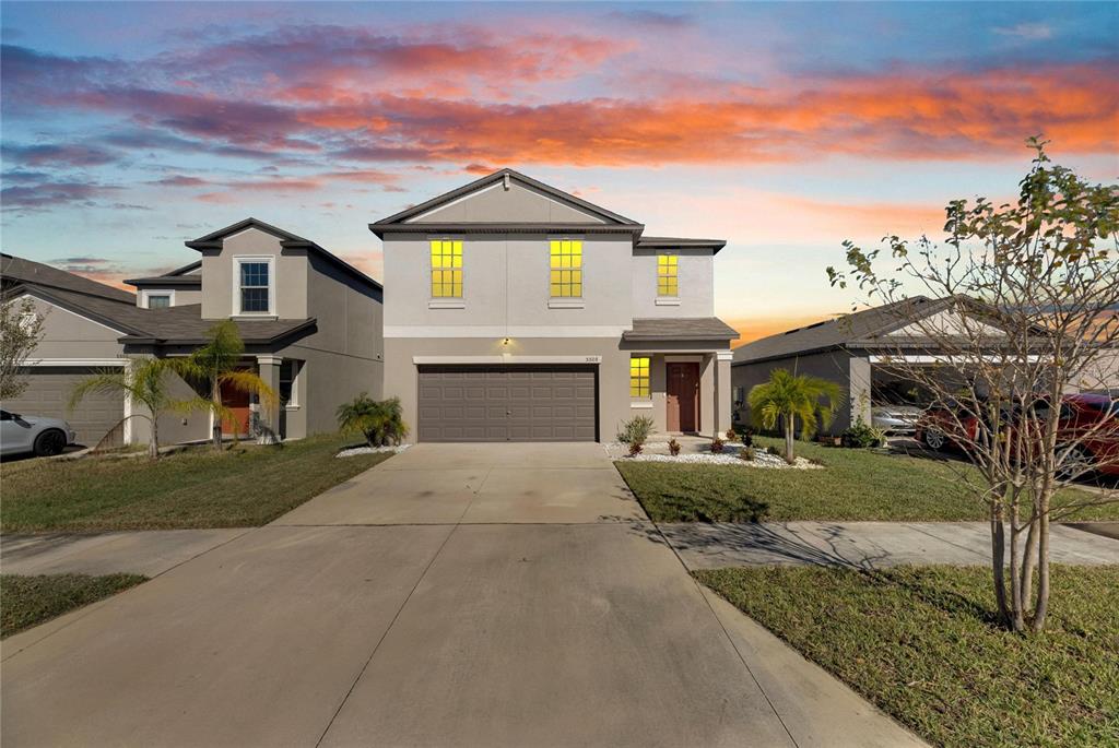 a front view of a house with a yard and garage