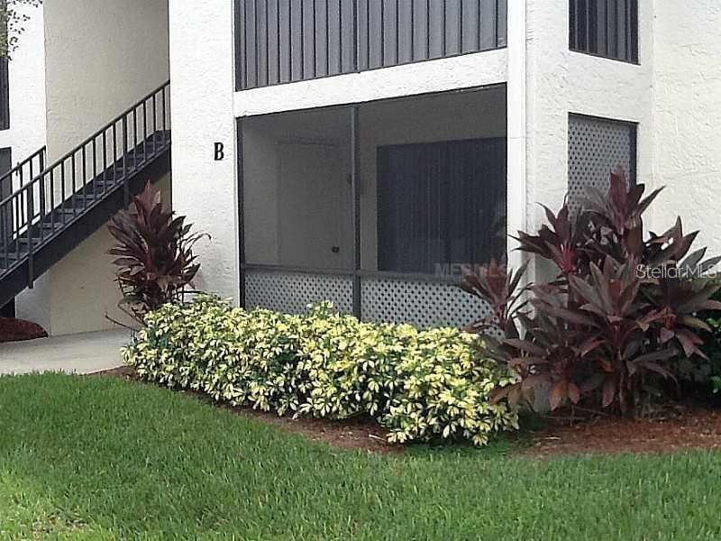 a garden with a bench in front of the house