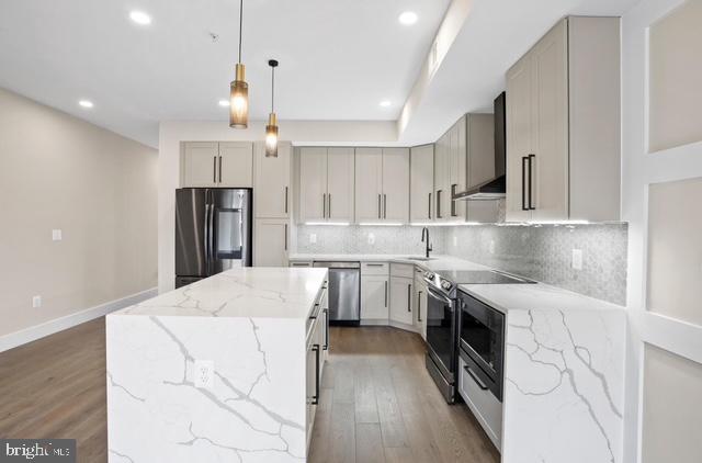 a kitchen with kitchen island a stove a sink and a refrigerator