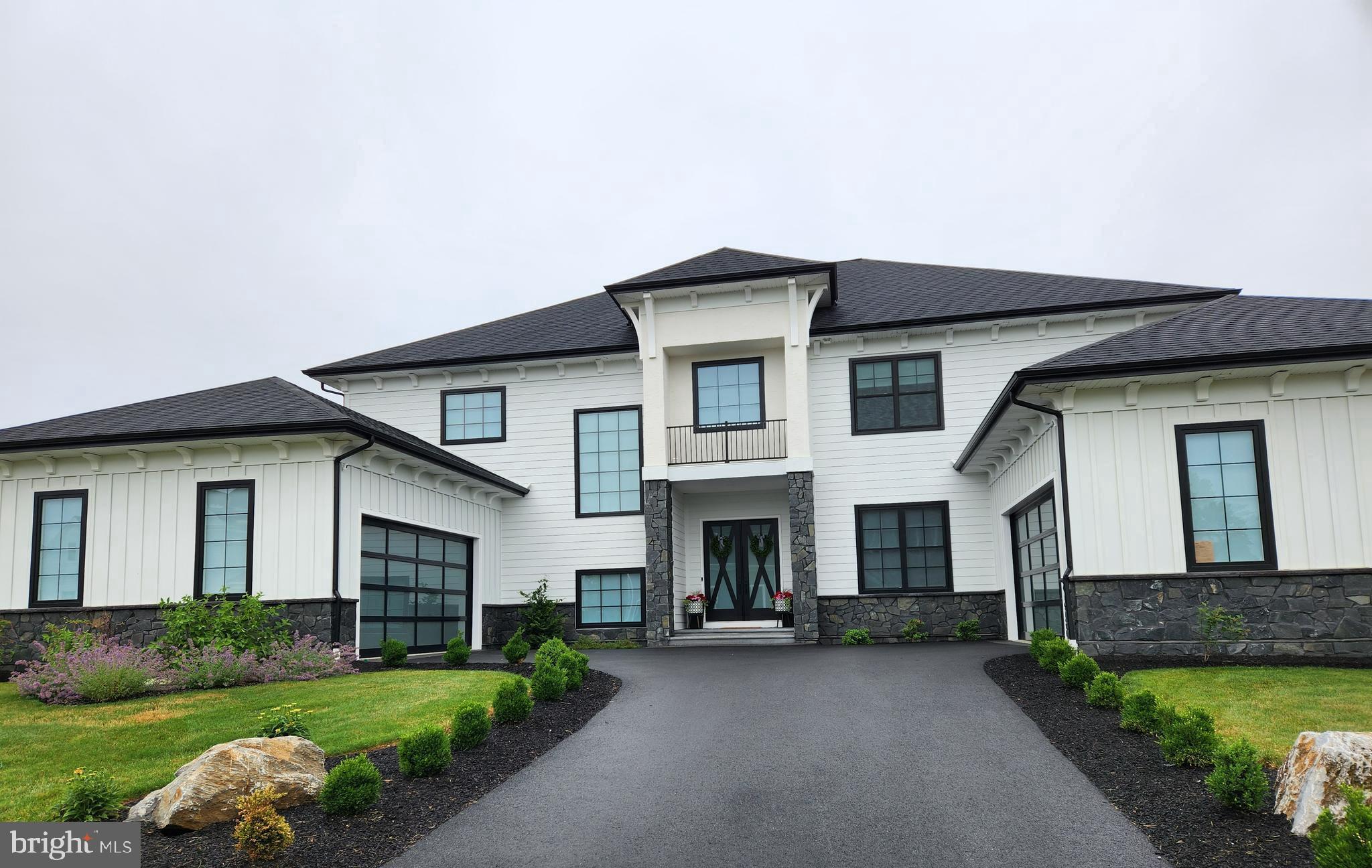 a front view of a house with a garden and yard