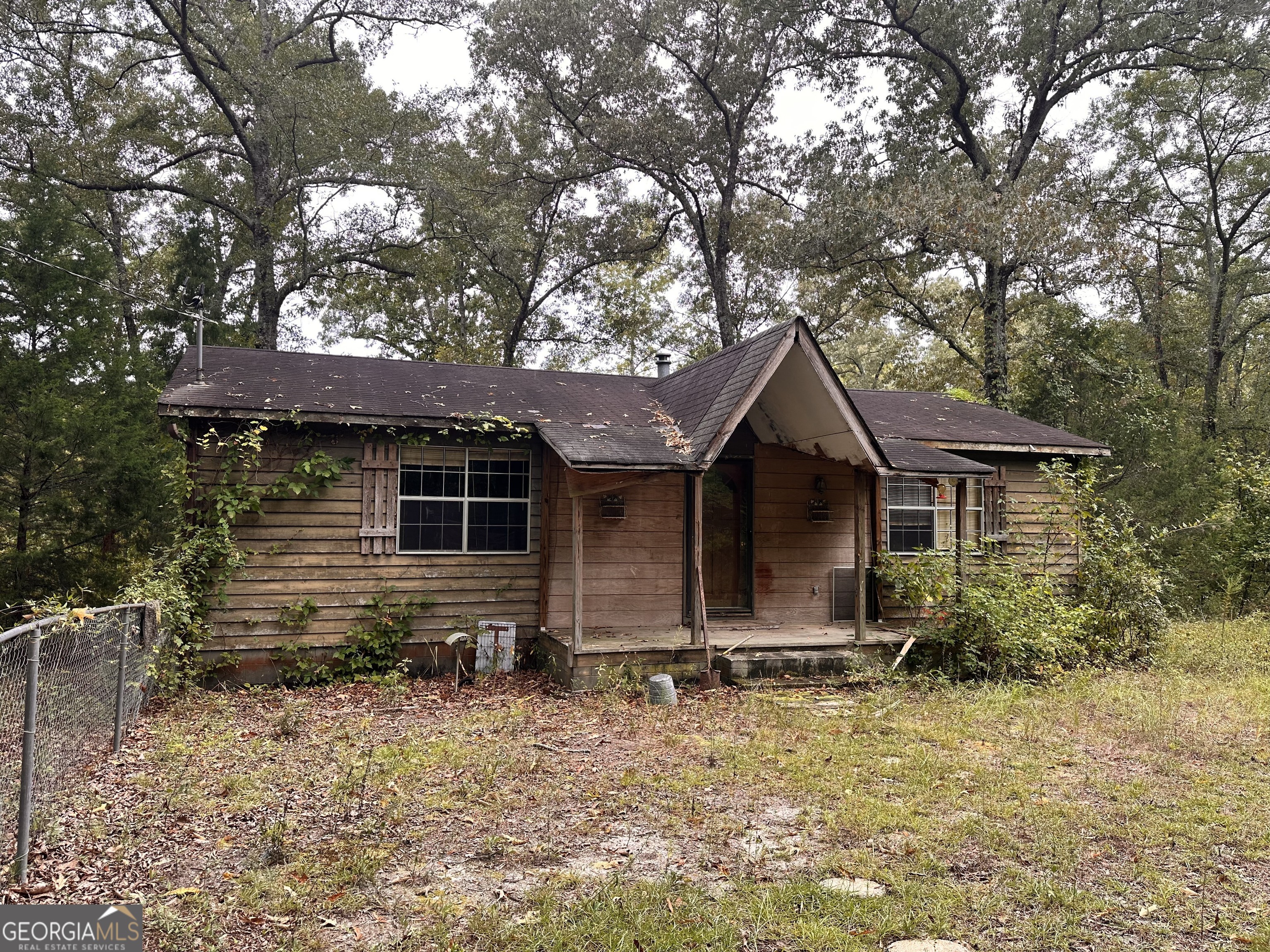 a front view of house with yard and trees in the background